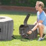 Intex PureSpa Greywood Deluxe: Aufblasbarer Whirlpool mit Mann bei der Installation im Garten.