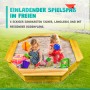 Sechseckiger Holzsandkasten Coemo mit zwei spielenden Kindern und Sandspielzeug im Garten.