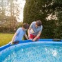Vater und Sohn reparieren Pool mit transparentem Tesa Reparaturband Ultra Power Under Water.