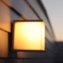 Lutec Box Cube Außenwandleuchte, anthrazitfarben, quadratisch, leuchtet warmweiß an Hauswand.