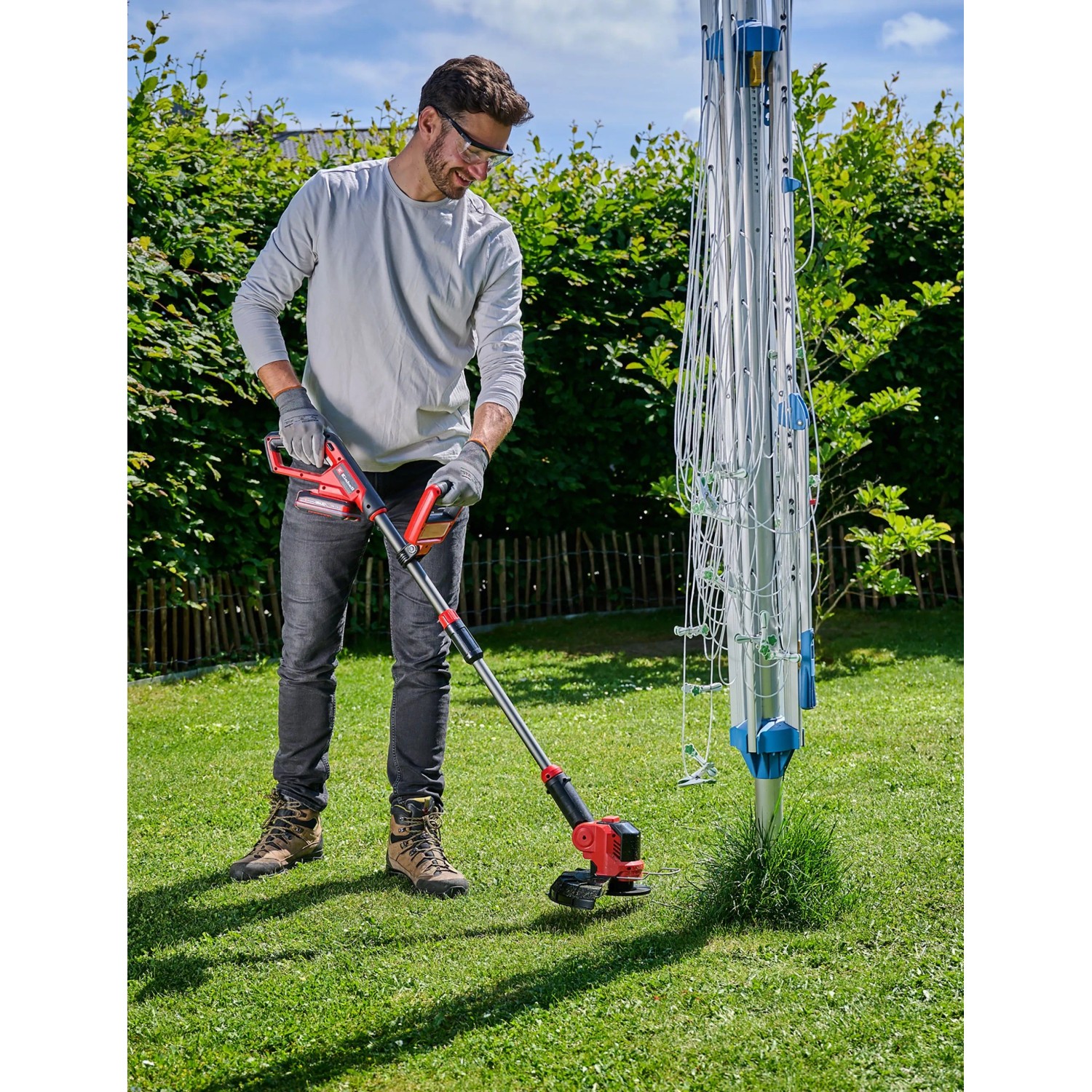 Einhell Akku-Rasentrimmer GE-CT 18/25-1 Li-Solo im Einsatz. Der Trimmer ist rot/schwarz und wird im Garten verwendet.