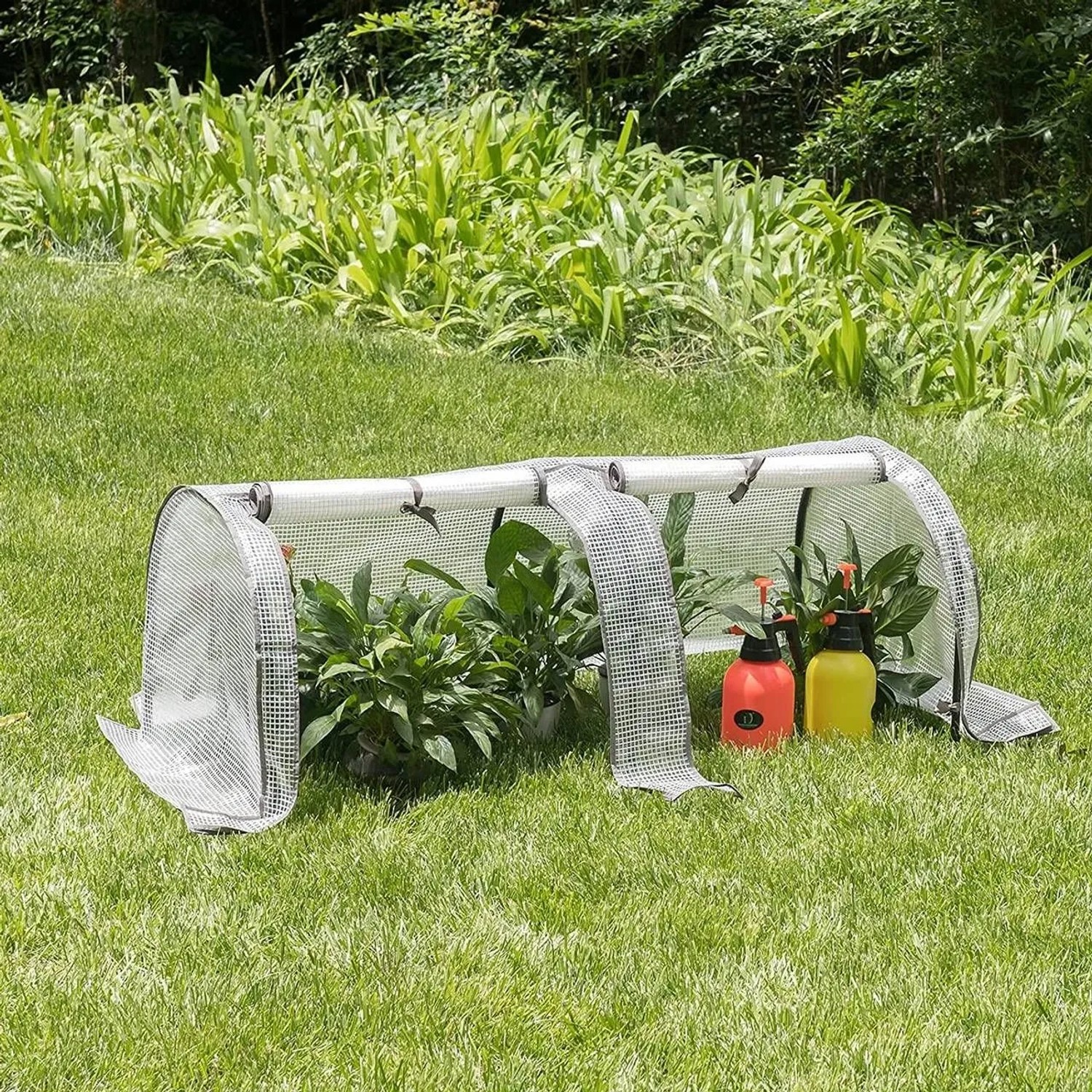 Halbtransparentes WOLTU Foliengewächshaus mit Pflanzen und Gartenspritzen im Garten.