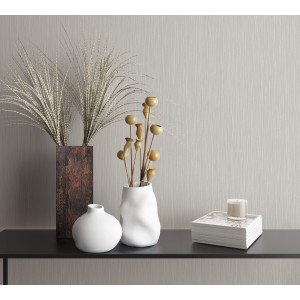 Helle Vliestapete Farbenspiel in Grau mit feiner Struktur, kombiniert mit Vasen und Dekoration.