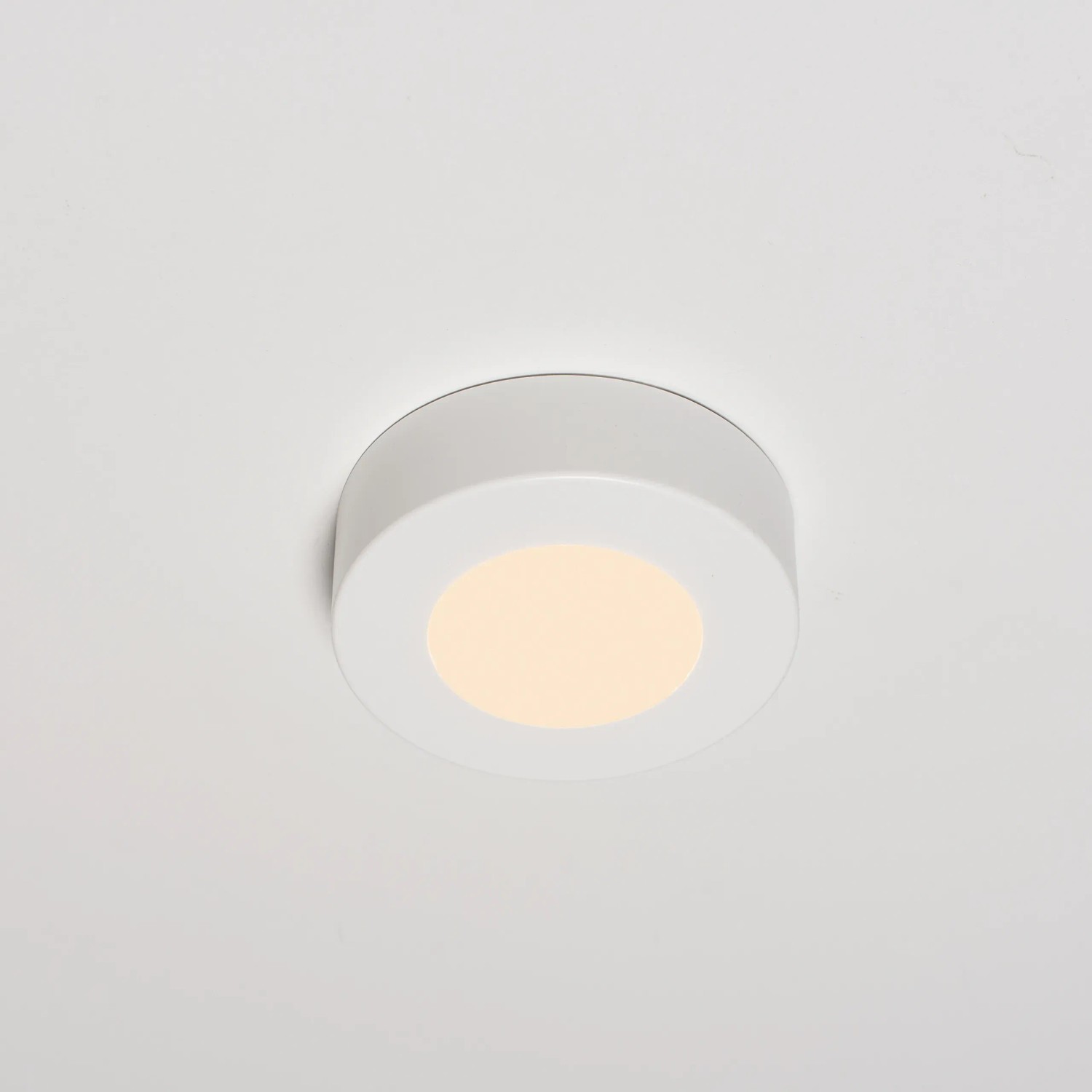 Weißer, runder LED Einbaustrahler, 6W, dimmbar, mit Opalglas montiert an einer Decke.