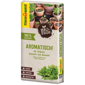 Sack Floragard Bio-Kräutererde Aromatisch 40 l mit Kräutern in Töpfen im Hintergrund.