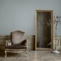 Graue Vliestapete Uni FSC®, passend zu elegantem Sessel und Spiegel im Jugendstil.