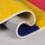 Gerollter Flair Rugs Kinderteppich Mambo, mehrfarbig mit geometrischen Blöcken aus Polypropylen, zeigt weiche Textur und weiße Kante.