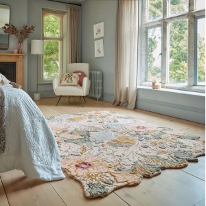 Flair Rugs Wollteppich Daphne Floral, mehrfarbig, mit geformten Kanten und Blumenmuster auf Holzfußboden im Schlafzimmer.
