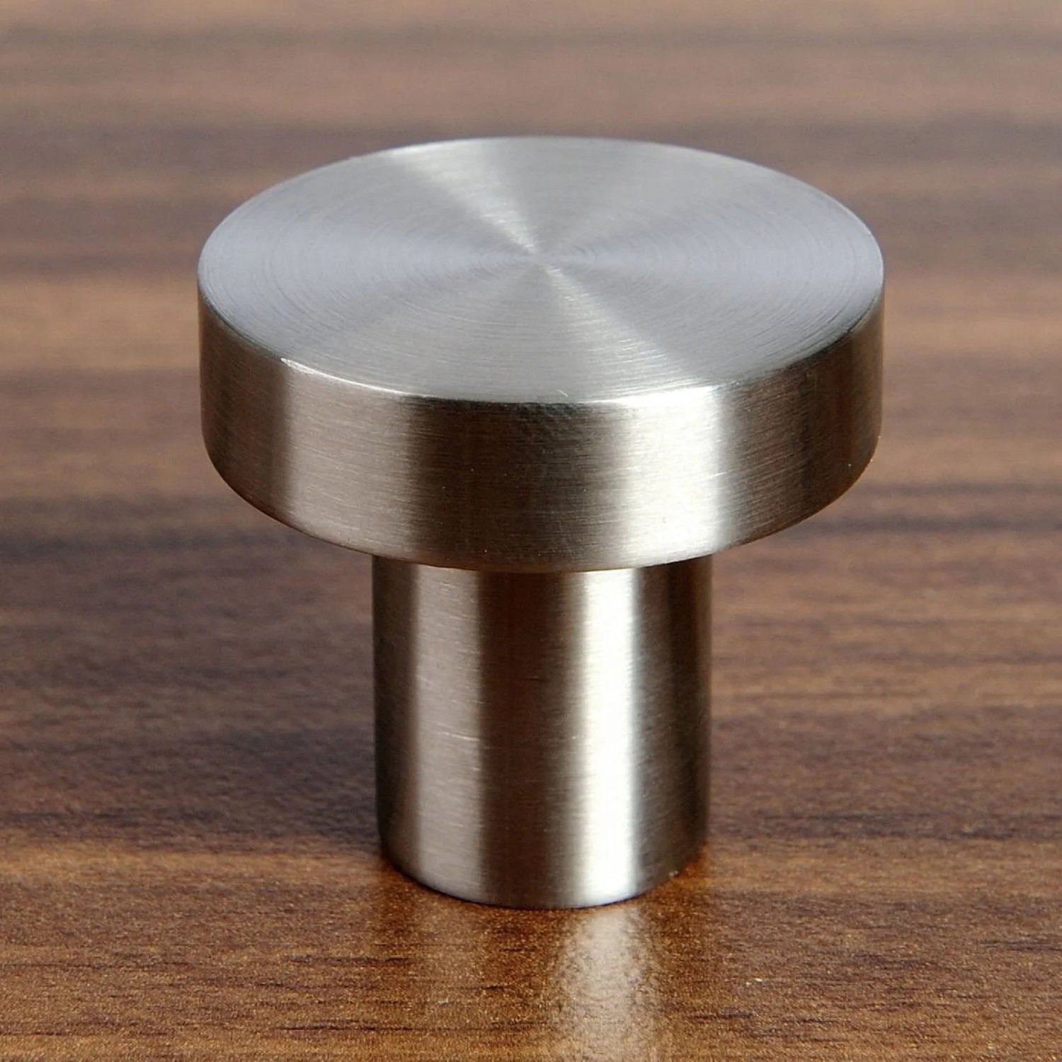 Runder SOTECH Möbelknopf EK03 aus gebürstetem Edelstahl, Ø30 mm, auf Holzoberfläche.