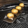 Rösle Kartoffelhalter aus Edelstahl mit vier Kartoffeln auf einem Grill.