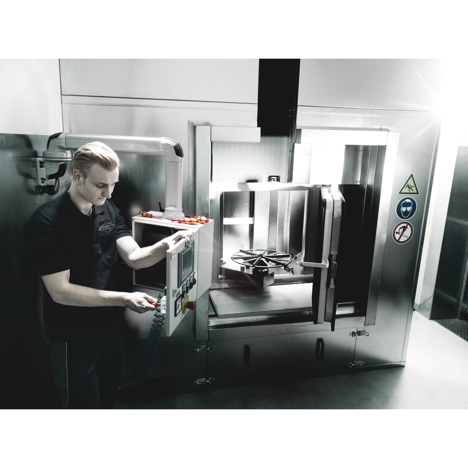 Anwendungsszene: Mann bedient Maschine mit Wera isoliertem Kreuzschlitz-Schraubendreher PH 1 x 80 mm.