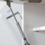 Detailaufnahme Lifttür-Beschlag im weißen Oberschrank der Respekta Premium Küchenzeile.