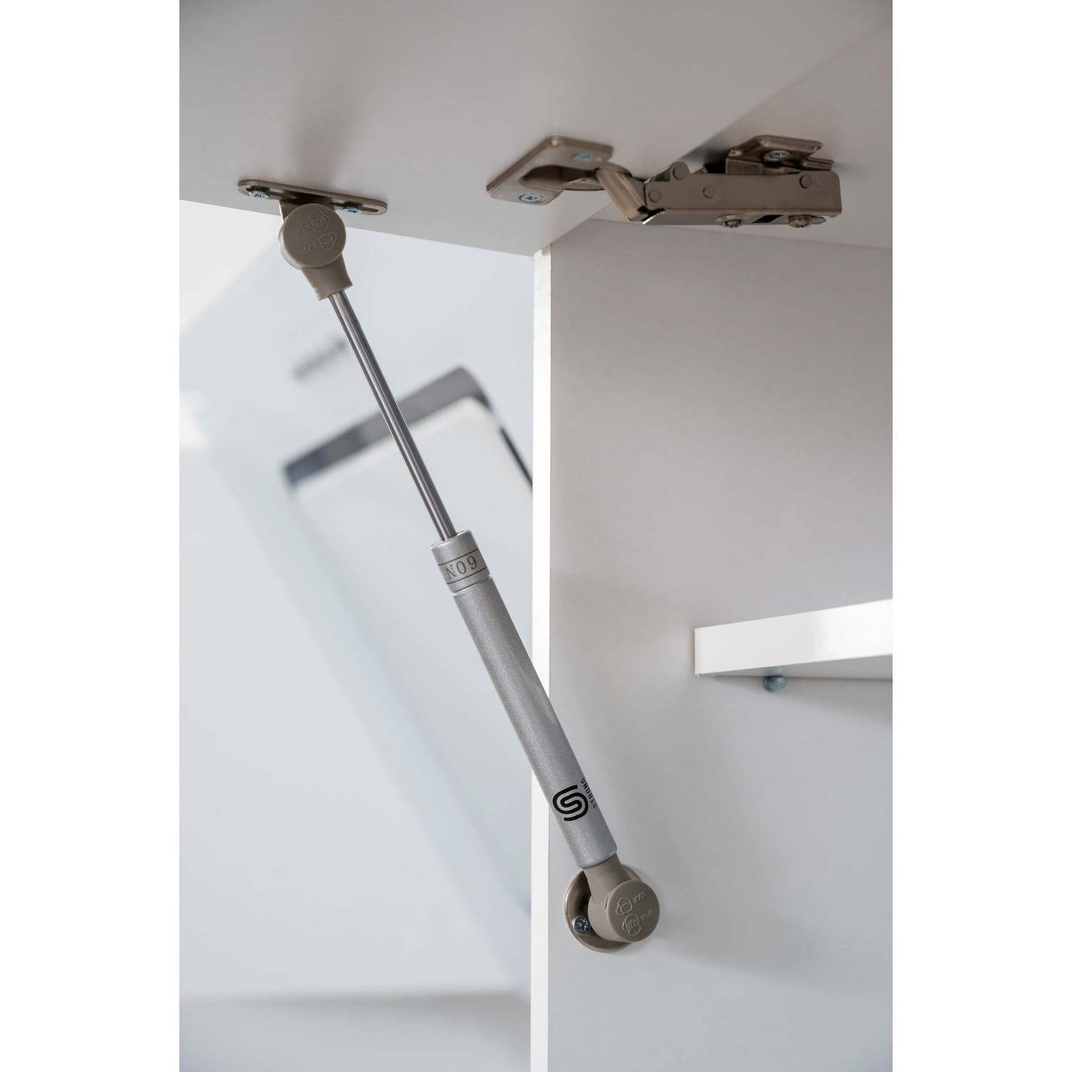 Detailaufnahme Lifttür-Beschlag im weißen Oberschrank der Respekta Premium Küchenzeile.