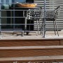 Dieda Geländerset aus Aluminium mit waagerechten Rundstäben auf einer Terrasse mit Gartenmöbeln.
