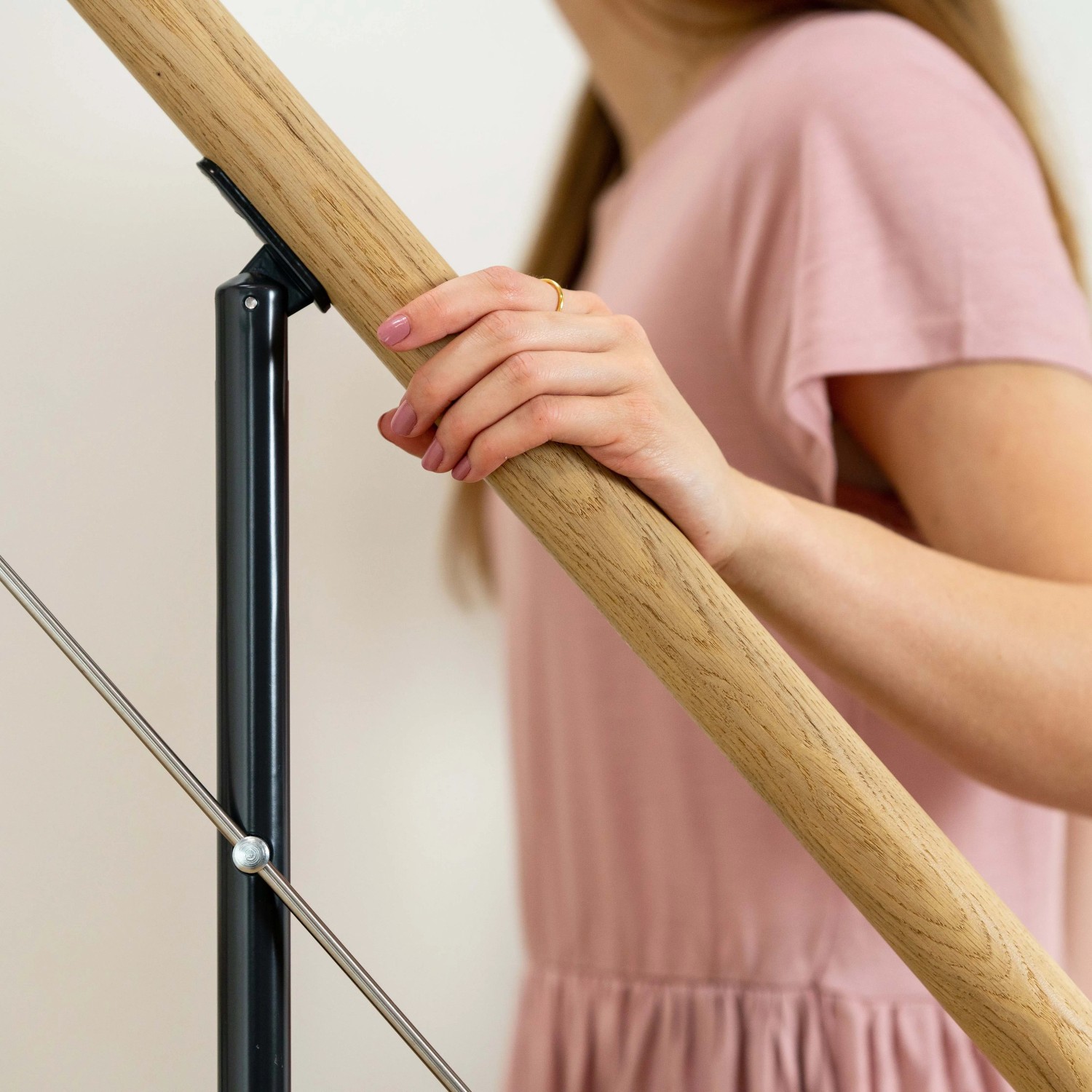 Detailaufnahme: Dolle Mittelholmtreppe Boston mit Eichenholz-Handlauf und anthrazitfarbenem Metallgeländer.