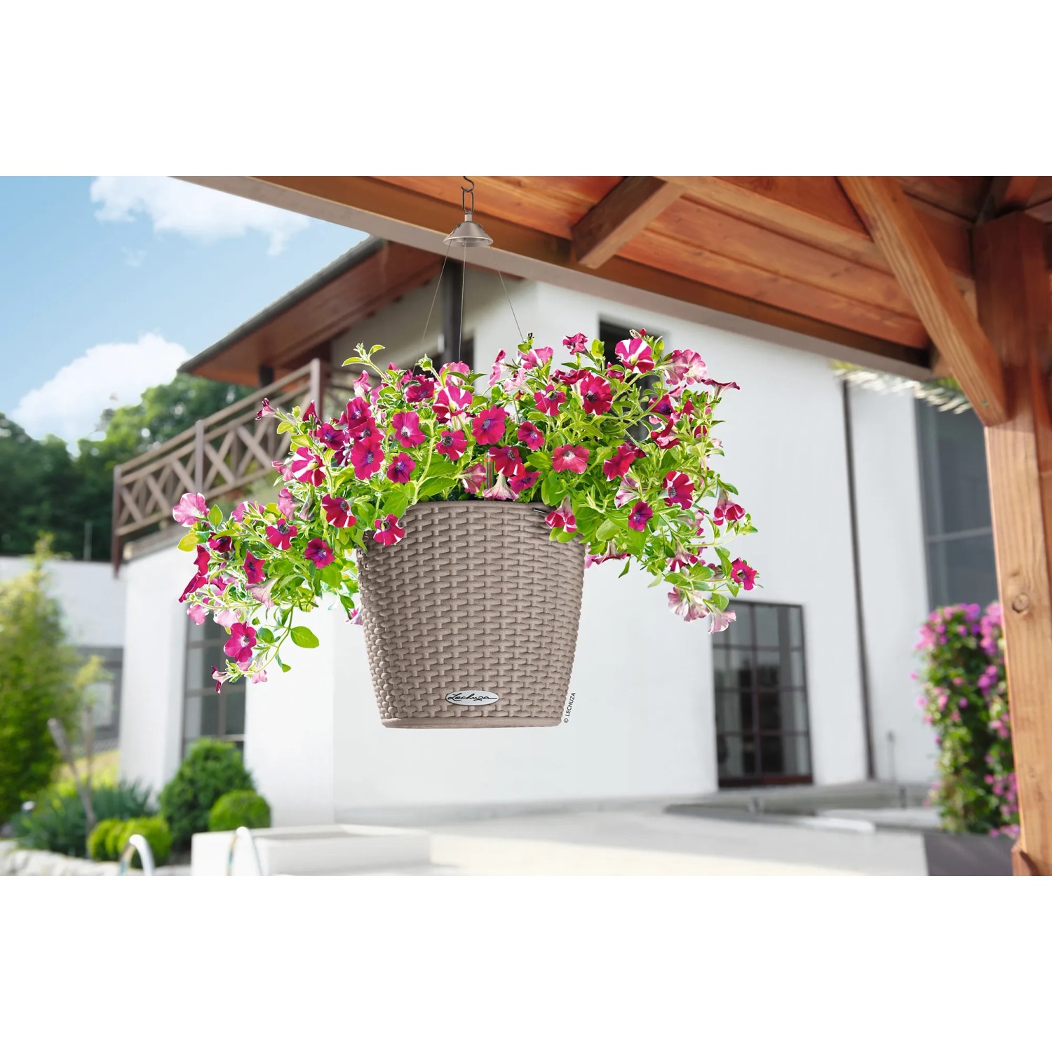 Sandbraune Lechuza Nido Cottage Blumenampel Ø 27cm mit blühenden Petunien.