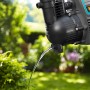 Gardena Haus- und Gartenautomat 4000/5 in Aktion: Wasserstrahl aus der Pumpe vor Gartenkulisse.