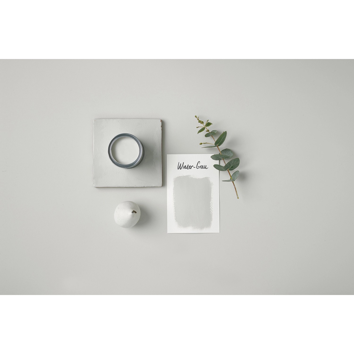 Rust-Oleum Kreidefarbe Winter-Grau, Farbmuster, Dose und Deko auf grauem Untergrund.