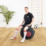 Mann sitzt auf schwarzem Sitting Ball Hocker FCB (120 l) mit Bayern München Logo.