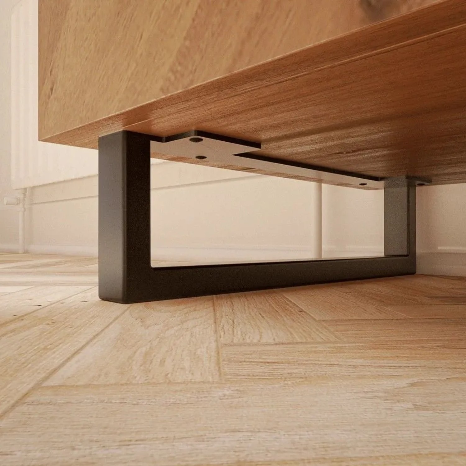 Schwarzes U-förmiges HEVVA Möbelbein GRAZ, 10 cm hoch, 40 cm tief, an Holzmöbel montiert auf hellem Holzboden.
