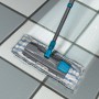 Bodenwischer mit blau-weißem Mikrofaser-Nassbezug für Fliesen- und Steinböden.