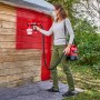 Frau lackiert Holz mit Einhell Akku Airbrush TE-SY 18/90 Li Solo Farbsprühgerät rot.
