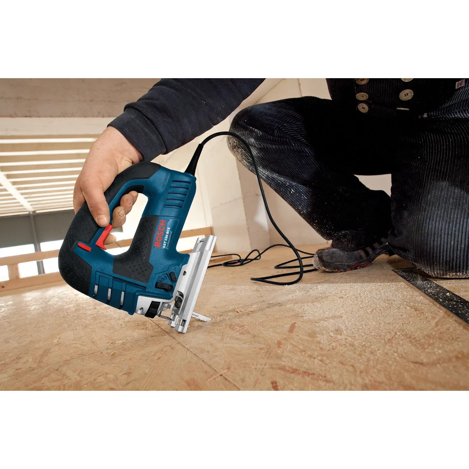 Bosch Professional GST 150 CE Stichsäge in Aktion, mit L-Boxx Zubehör. Blaue Stichsäge beim Sägen von Holz.