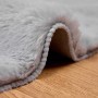 Grauer, runder Kunstfell Teppich Olite aus Polyester. Weiche, flauschige Textur auf Holz. Gemütlicher Bodenbelag.