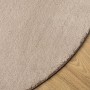 Sandfarbener runder Kurzflor-Teppich HUARTE (Ø 80 cm) auf Holzfußboden. Weich, flauschig und waschbar.