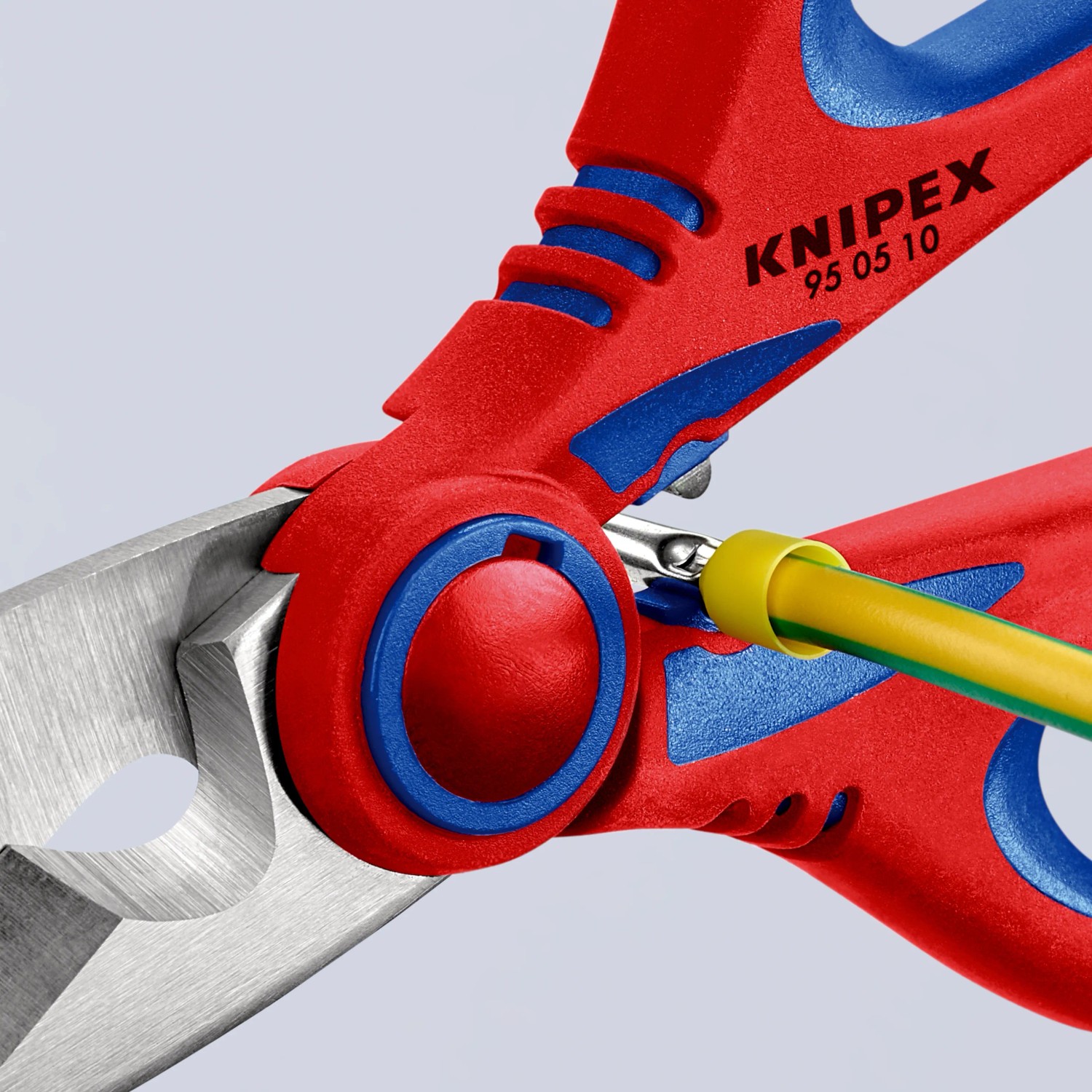 Knipex Elektrikerschere 160 mm, rot/blaue Griffe, schneidet ein gelb-grünes Kabel.