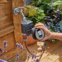 Gardena Bewässerungscomputer Flex am Wasserhahn mit Display in der Hand.