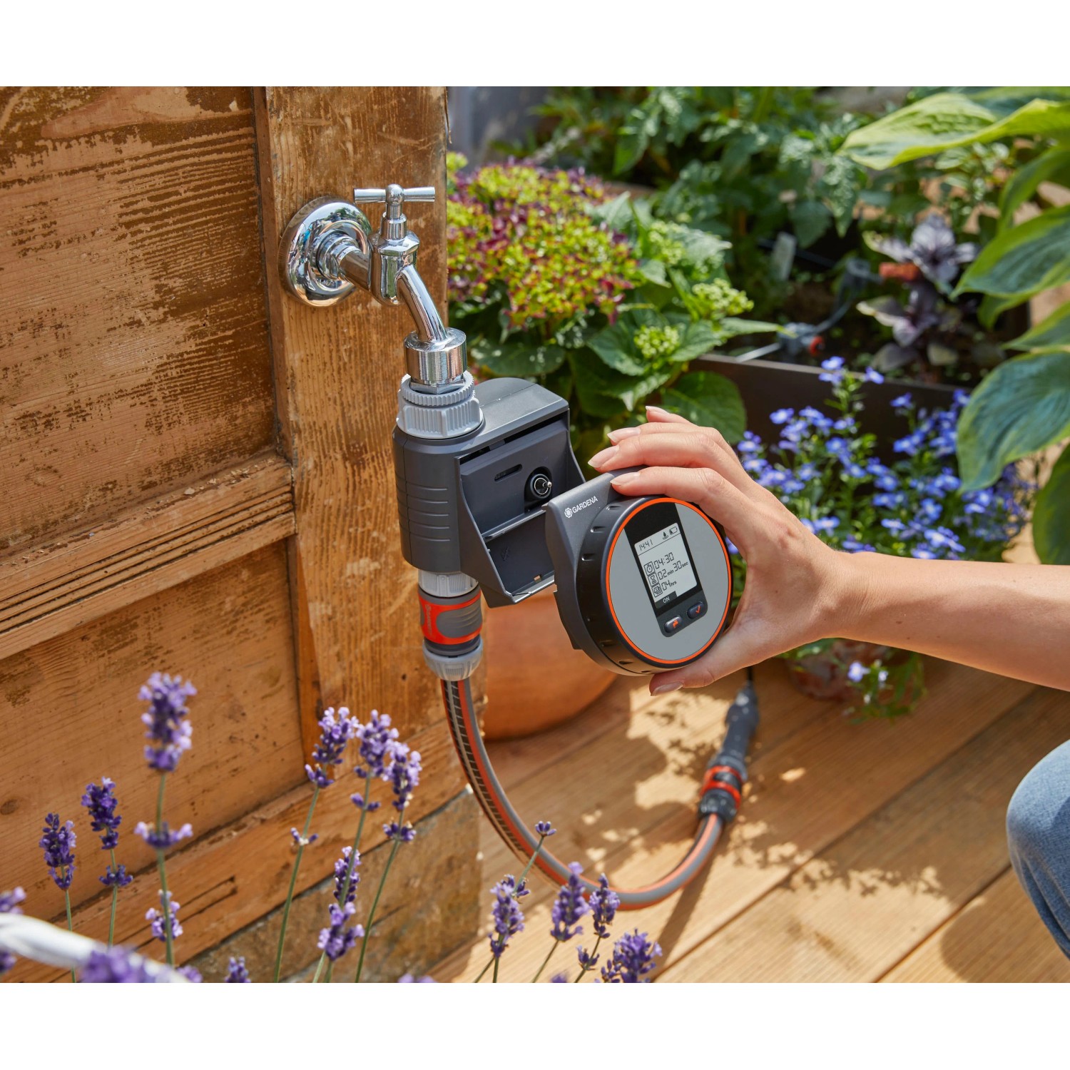 Gardena Bewässerungscomputer Flex am Wasserhahn mit Display in der Hand.