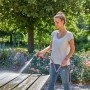 Frau reinigt Gartentisch mit Gardena Comfort Reinigungsspritze ecoPulse™.
