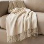 Elfenbeinfarbene Sofadecke aus Baumwoll-Mix mit Fransen, elegant über einem Sofa. Vielseitige Wohndecke.