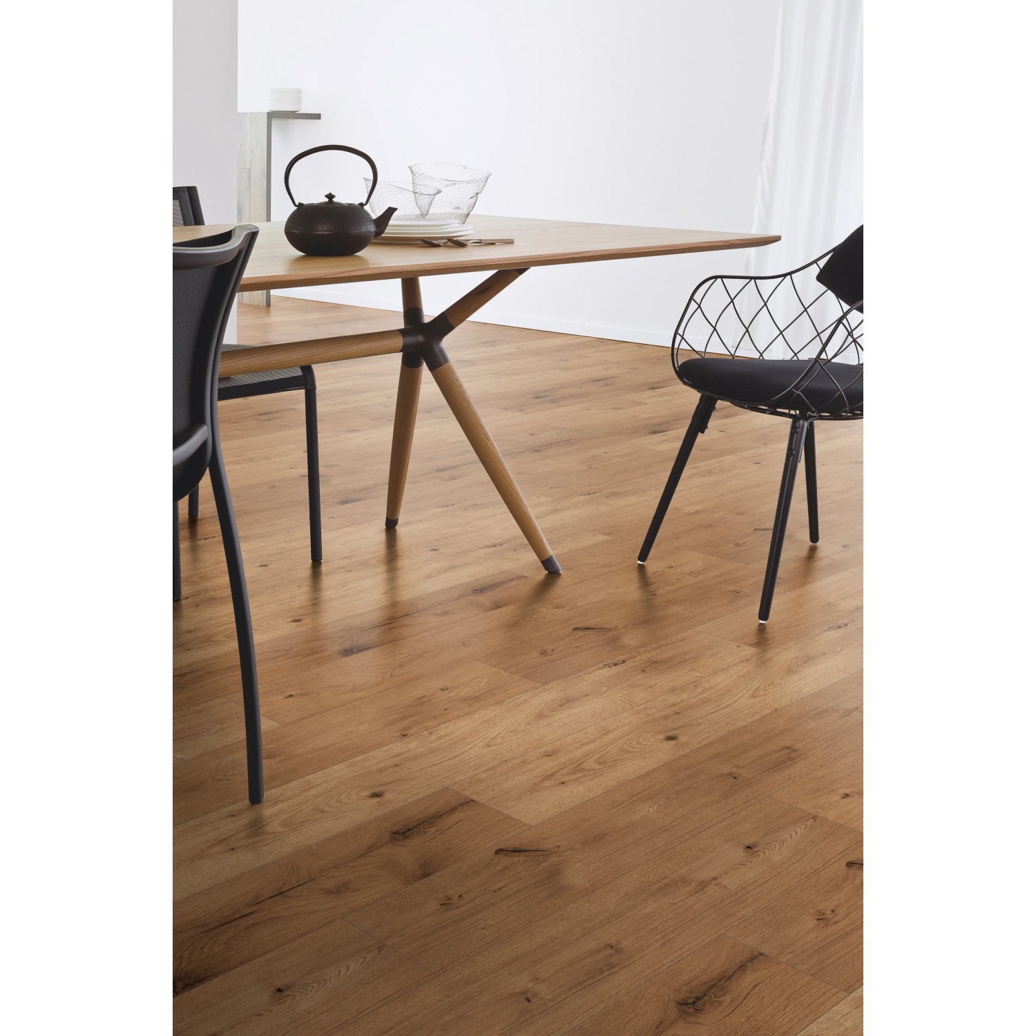 Kaindl Laminat Eiche Ferrara, 8mm stark. Wohnraum-Szene mit Esstisch und Stühlen auf dem Laminatboden.
