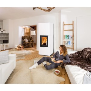 Weißer Haas+Sohn Kaminofen Dachstein mit Wärmespeicherbeton im Wohnraum mit brennendem Feuer.