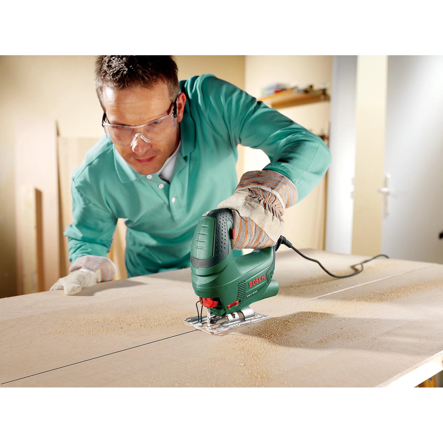 Bosch PST 650 Stichsäge in Aktion: Mann sägt Holzbrett mit der grünen Stichsäge.