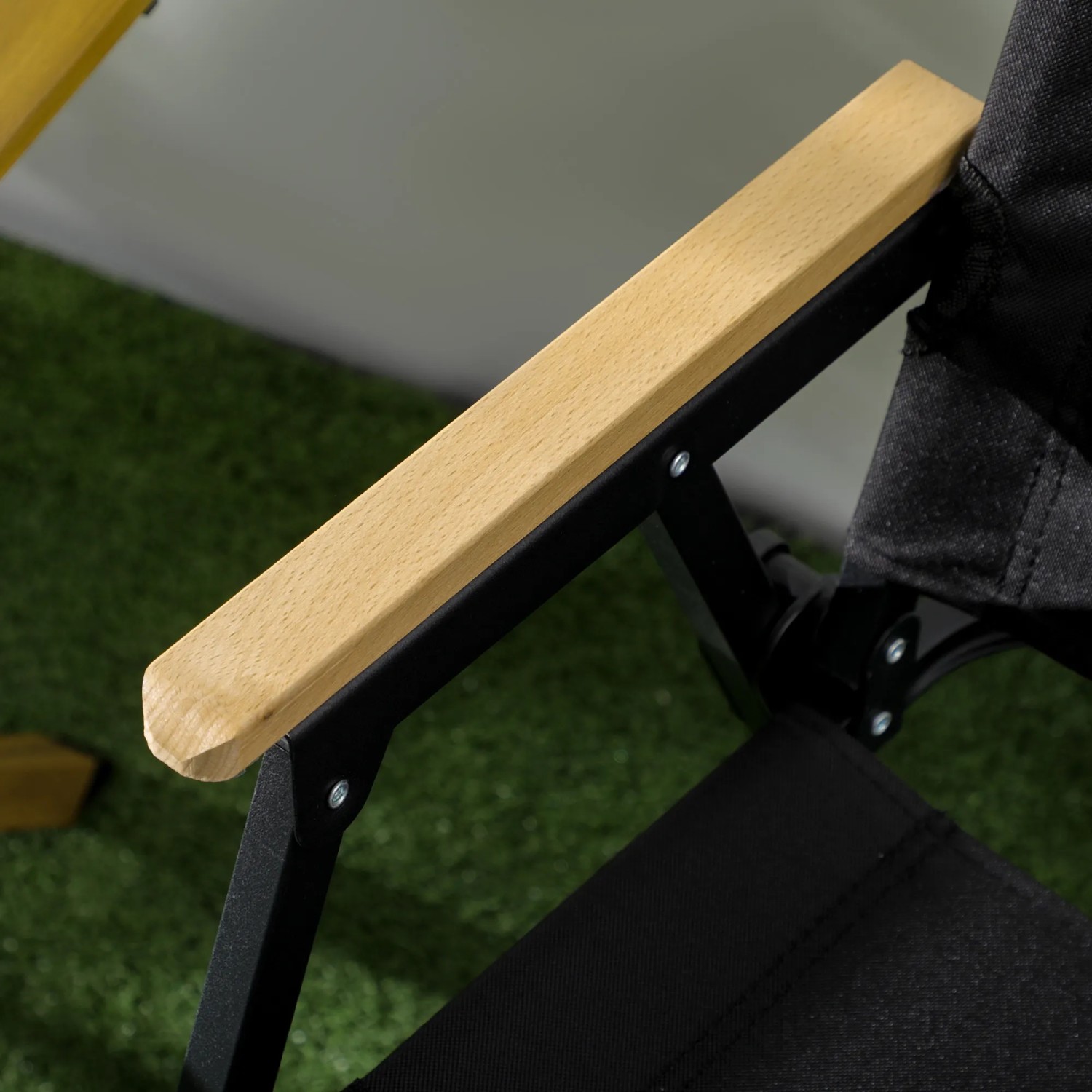 Detailansicht: Armlehne aus Holz und Stahlgestell des schwarzen Outsunny Campingstuhls.