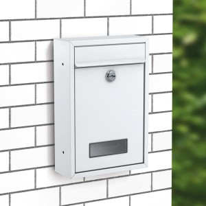 Weißer Basi Briefkasten mit Zylinderschloss an einer weißen Ziegelwand.