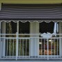 Angerer Klemmmarkise, schokobraun-creme gestreift, 150x150 cm, am Balkon montiert.