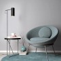 Graue Erismann Vliestapete Melissa Elin (FSC®) an Wand hinter Sessel und Lampe.