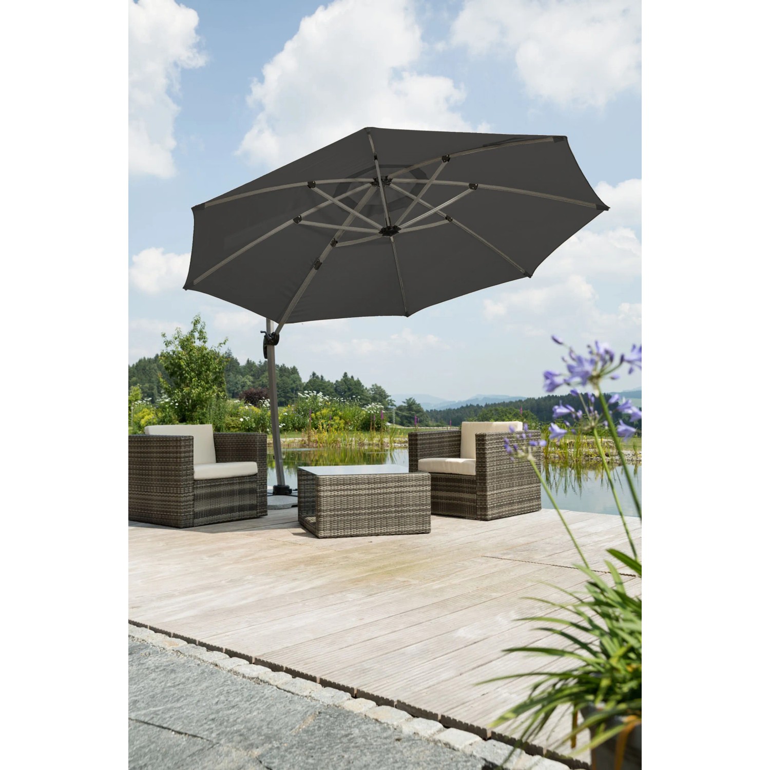 Anthrazit Schneider Ampelschirm Rhodos Ø 350 cm mit Kurbel über Lounge-Set auf Terrasse.