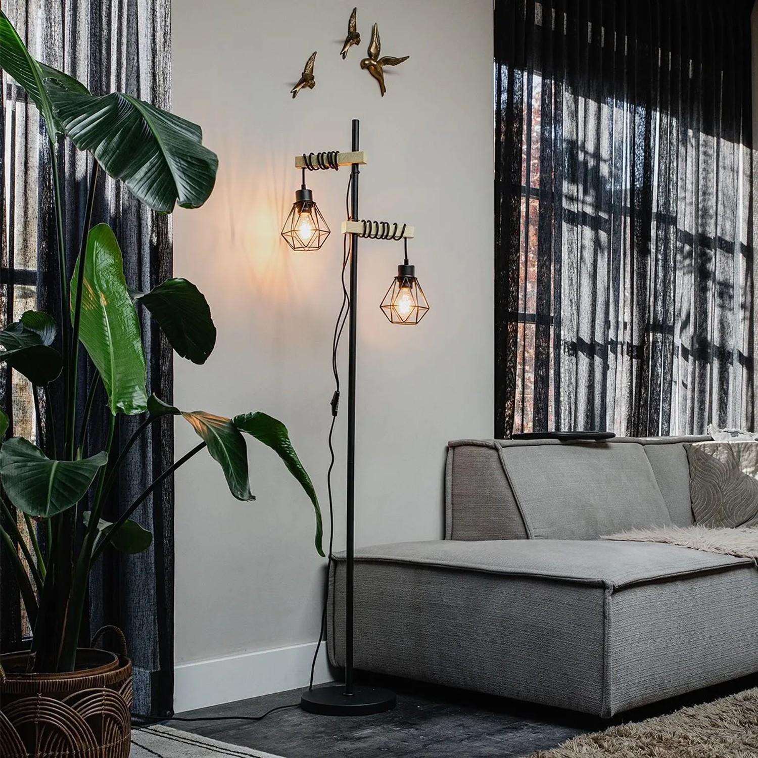 Schwarze QAZQA Stehlampe Chon mit Holz und zwei Leuchten im Wohnzimmer.