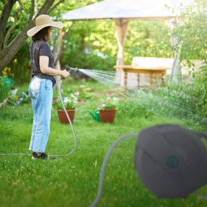 Grauer Ecd Germany Schlauchaufroller 20m im Garten. Person bewässert Pflanzen mit Gartenschlauch und Spritzdüse.