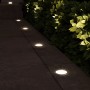Eingebaute, runde LED Bodenleuchten Viskos von SSC-LUXon beleuchten einen dunklen Gartenweg mit warmweißem Licht.
