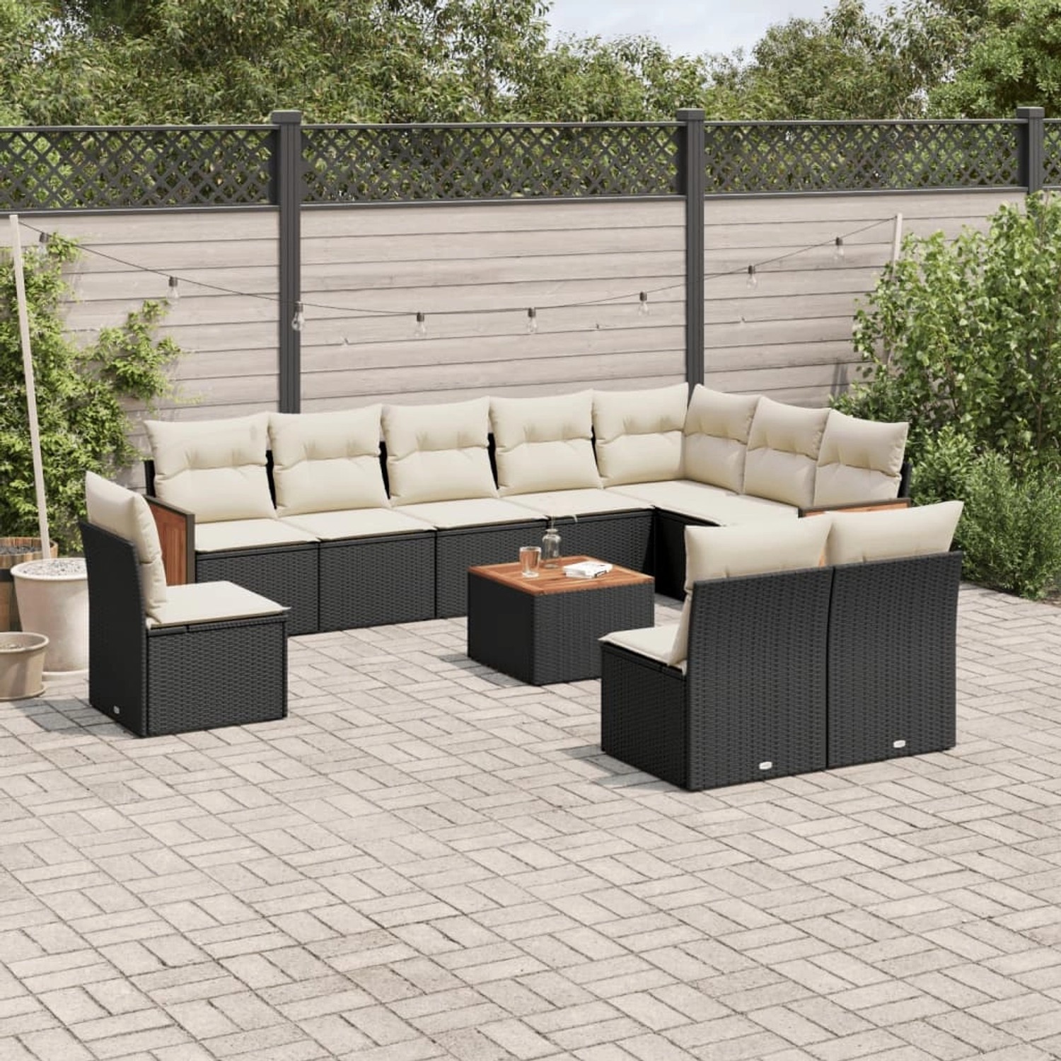 Schwarze 11-tlg. Garten-Sofagarnitur aus Poly Rattan mit cremefarbenen Kissen und Akazientisch.