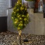 Konstsmide LED Lichterkette mit 80 warmweißen LEDs an kleinem Baum im Außenbereich.