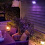 Philips Hue Econic LED-Sockelleuchte im Garten mit farbigem Licht. Außenleuchte aus Aluminium, wetterfest.