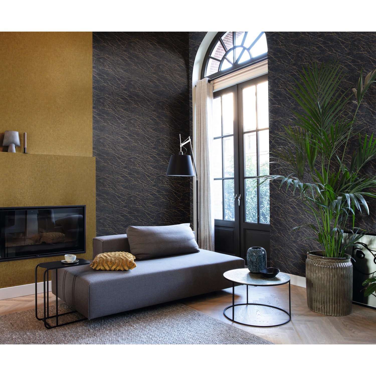 Wohnraum mit Rasch Vliestapete Factory IV 429312 in Gold-Gelb und dunklem Muster.