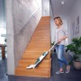 Frau reinigt Treppe mit Leifheit Akku-Saugwischer Regulus Aqua PowerVac.